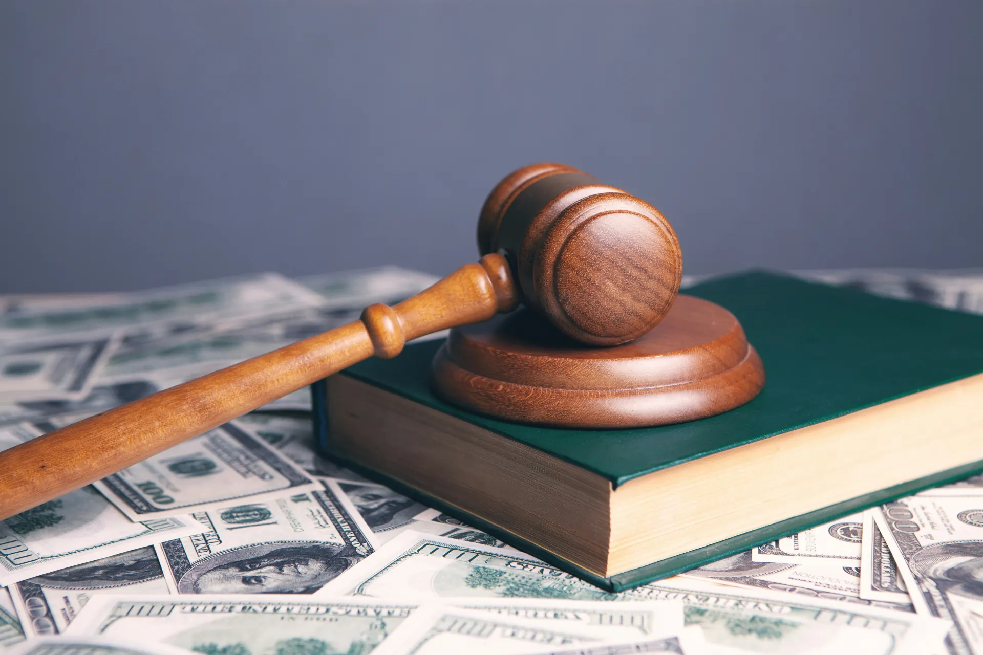 Marteau de juge posé sur un livre vert et des billets, symbolisant le risque de redressement URSSAF